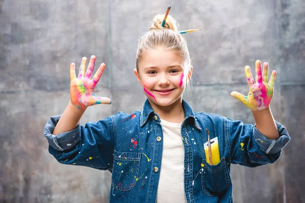 Schoolgirl artist with painted face — Stock Photo