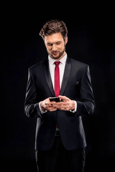 Hombre de negocios guapo usando teléfono inteligente - foto de stock