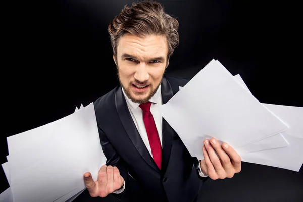 Annoyed businessman holding papers — Stock Photo