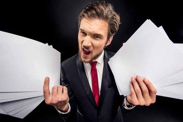 Annoyed businessman holding papers — Stock Photo