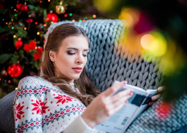 Livre de lecture femme sur canapé — Photo de stock