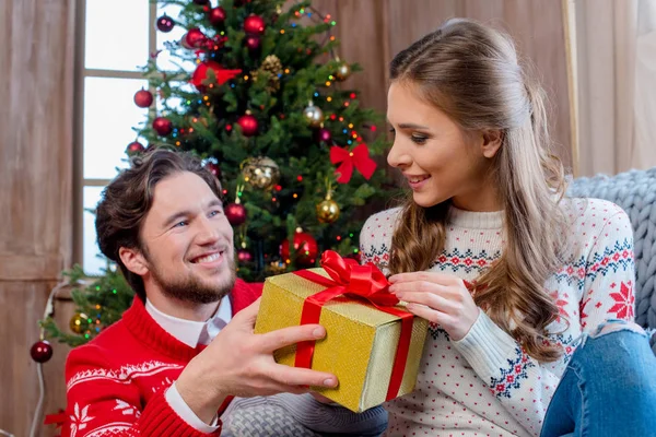 Pareja feliz con regalo de Navidad - foto de stock