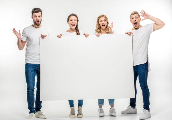 Amigos sosteniendo tarjeta en blanco - foto de stock