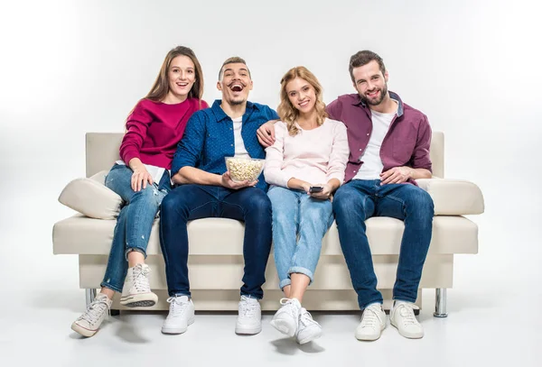 Smiling friends sitting on couch — Stock Photo
