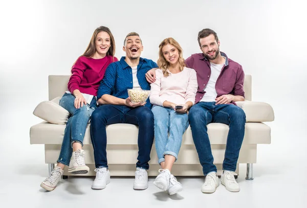 Amigos sonrientes sentados en el sofá - foto de stock