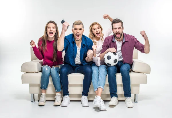 Amigos sentados no sofá com bola de futebol — Fotografia de Stock