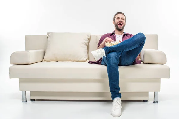 Homem sentado no sofá com pipocas — Fotografia de Stock