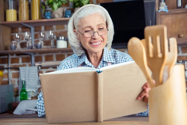 Mulher sênior com livro de receitas — Fotografia de Stock