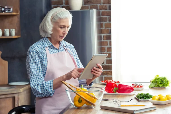 Женщина с помощью цифрового планшета на кухне — стоковое фото