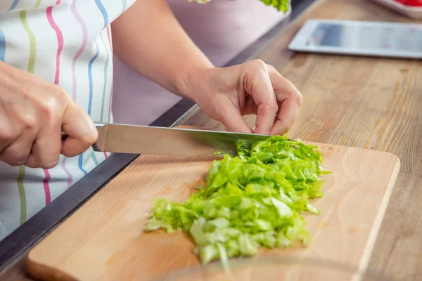 Frau schneidet Salatgemüse — Stockfoto