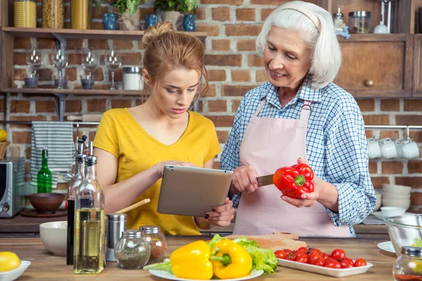 Granddaughter and grandmother cooking together — Stock Photo