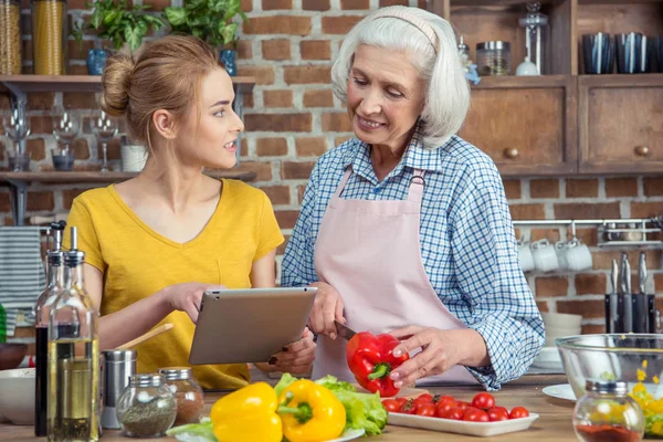 Petite-fille et grand-mère cuisinent ensemble — Photo de stock