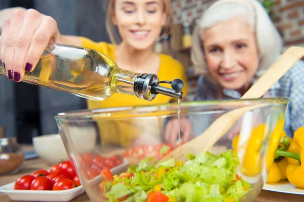 Granddaughter and grandmother cooking together — Stock Photo