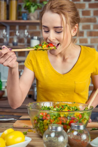 Mujer degustación de ensalada de verduras - foto de stock