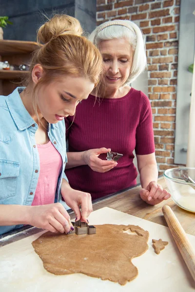 Grandmother and granddaughter making cookies — Stock Photo