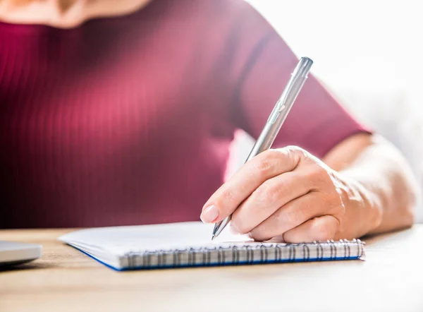 Woman writing in notebook — Stock Photo