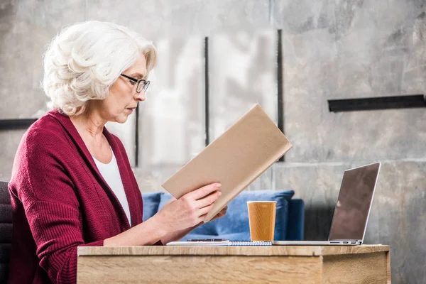 Senior woman reading book — Stock Photo