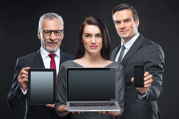 Tres empresarios con dispositivos - foto de stock