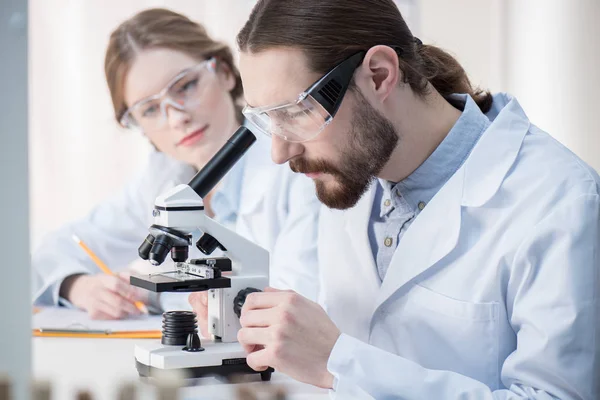 Homme regardant au microscope — Photo de stock