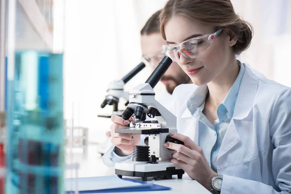 Female scientist working with microscope — Stock Photo