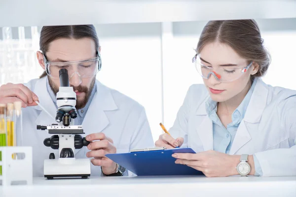 Chemiker arbeiten mit Mikroskop — Stockfoto