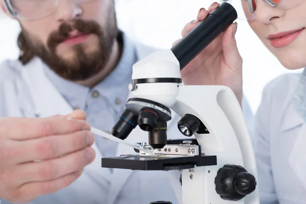 Químicos trabajando con microscopio - foto de stock