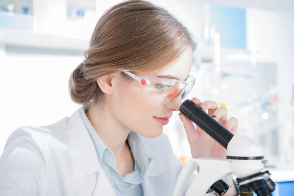 Female scientist working with microscope — Stock Photo