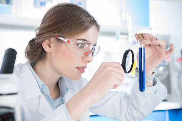 Cientista olhando no tubo de ensaio — Fotografia de Stock