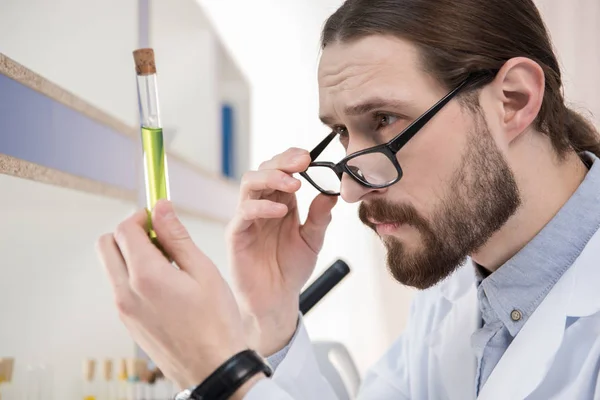 Cientista olhando no tubo de ensaio — Fotografia de Stock
