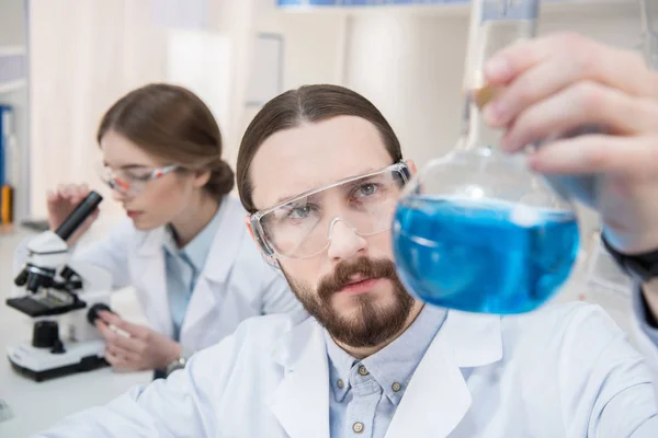 Scientist holding chemical reagent — Stock Photo