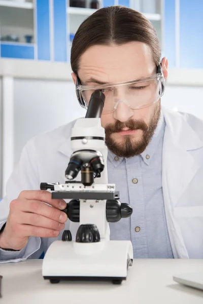 Man looking in microscope — Stock Photo