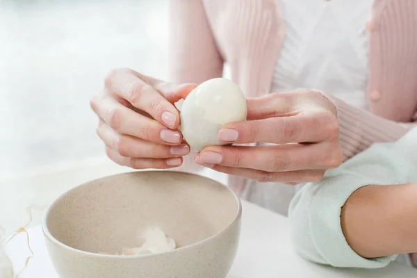 Woman peeling boiled egg — Stock Photo