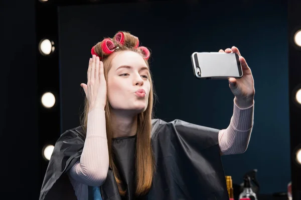 Woman in curlers taking selfie — Stock Photo