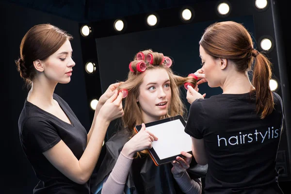 Hairstylists curling hair to woman — Stock Photo