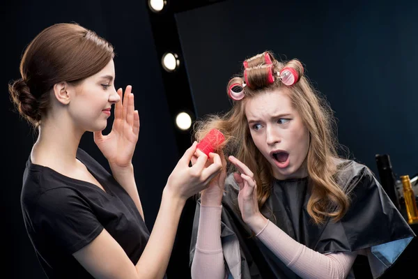 Hairstylist curling hair to woman — Stock Photo