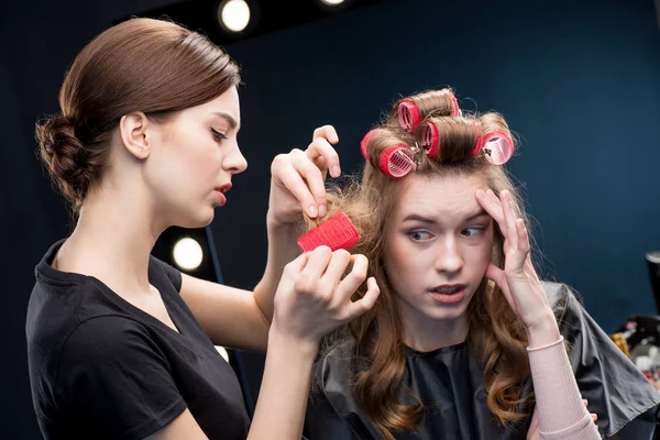 Hairstylist curling hair to woman — Stock Photo