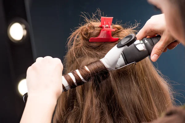 Hairstylist curling hair — Stock Photo