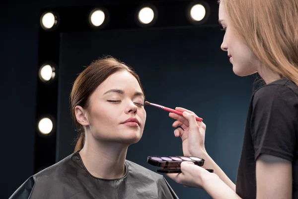 Maquillador aplicando sombra de ojos - foto de stock