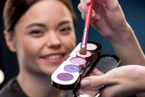 Woman picking up color of eyeshadows — Stock Photo