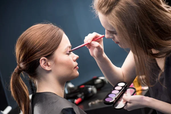 Visagistin trägt Lidschatten auf — Stockfoto