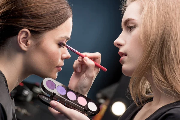 Maquillador aplicando sombra de ojos - foto de stock