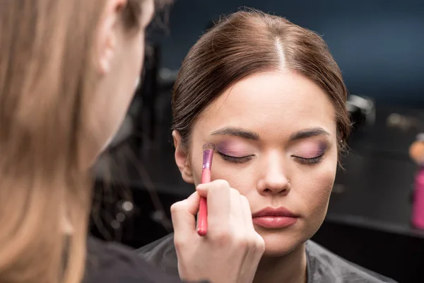 Maquillador aplicando sombra de ojos - foto de stock