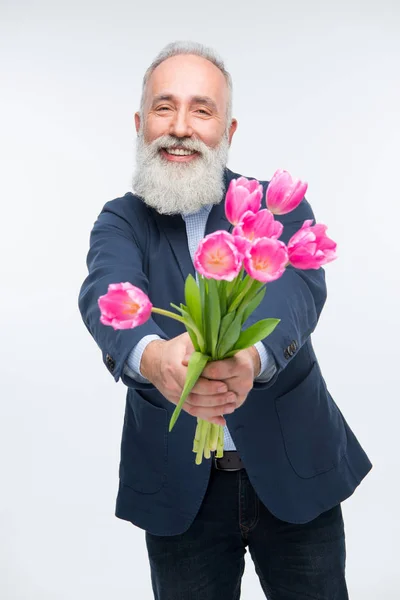 Hombre mayor con tulipanes - foto de stock