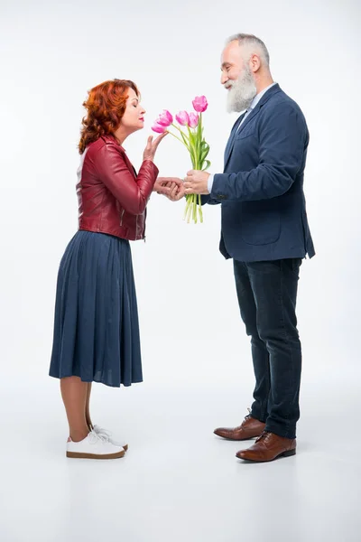 Hombre presentando flores a la mujer - foto de stock