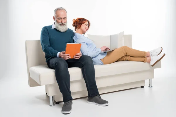 Couple utilisant ordinateur portable et tablette numérique — Photo de stock