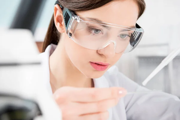 Female scientist in protective glasses — Stock Photo