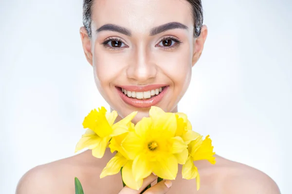 Mulher segurando narcisos amarelos — Fotografia de Stock