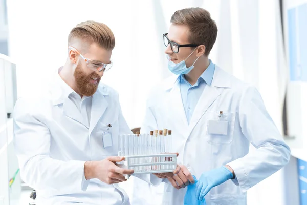 Chemists holding test tubes — Stock Photo