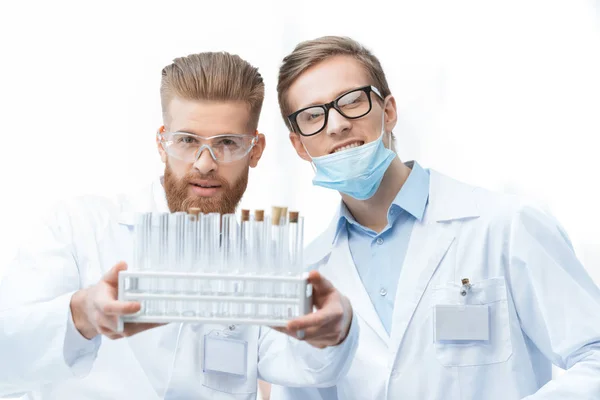 Chemists holding test tubes — Stock Photo