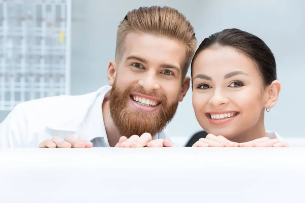 Scientists hiding behind table — Stock Photo